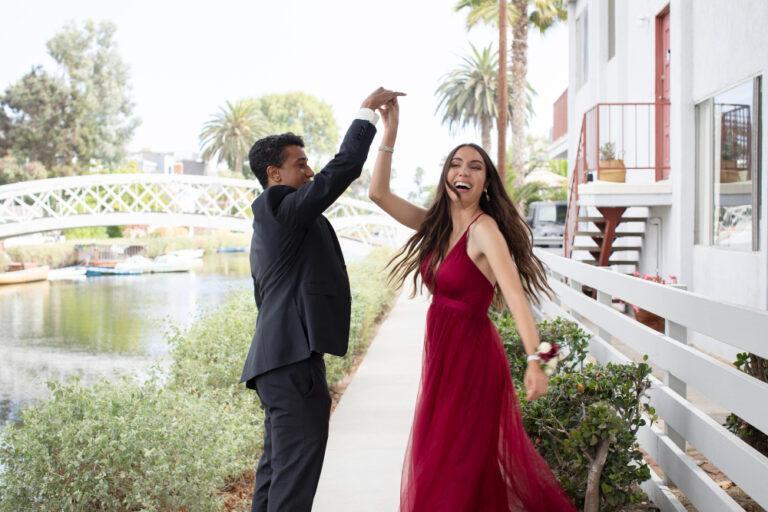 A man and woman in formal clothing dance on a bridge, showcasing elegance and joy for NJ wedding and birthday celebrations.