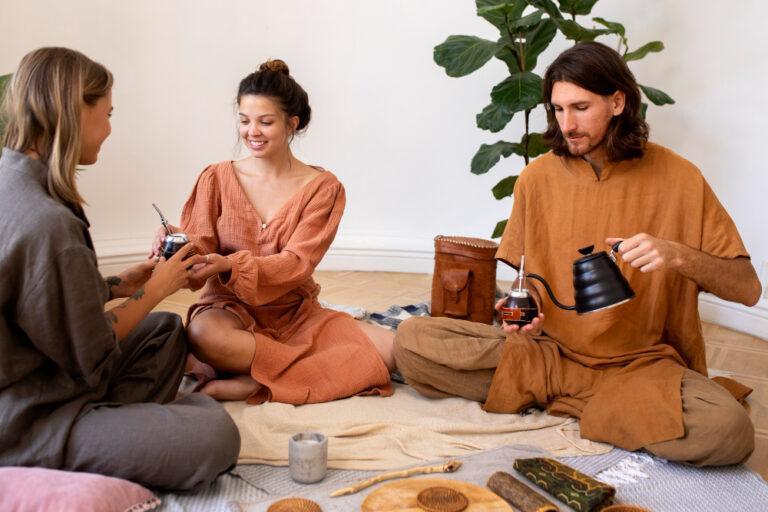Three individuals sitting on the floor with tea and snacks, discussing spiritual guidance and psychic readings in California.